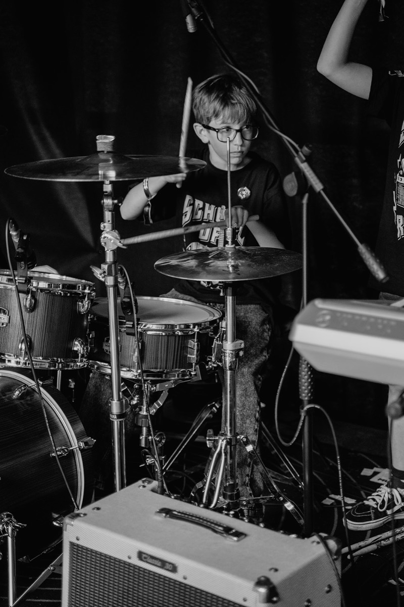 Junger Schlagzeuger konzentriert hinter dem Drumset, schwarz-weiß