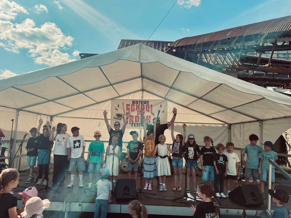 Die ganze Band jubelt mit erhobenen Armen auf der Bühne im Stöffel-Park