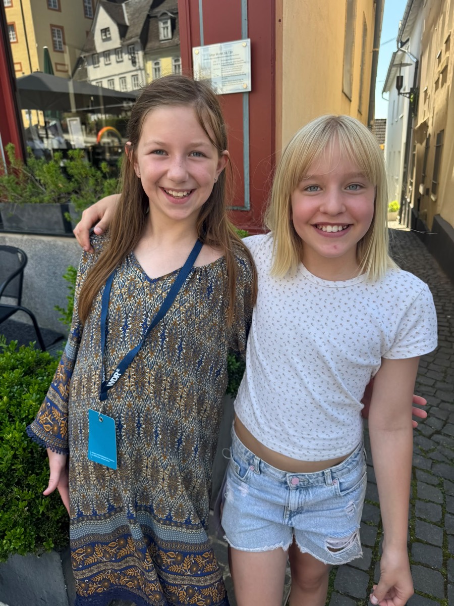 Zwei Mädchen lachen Arm in Arm in der Altstadt