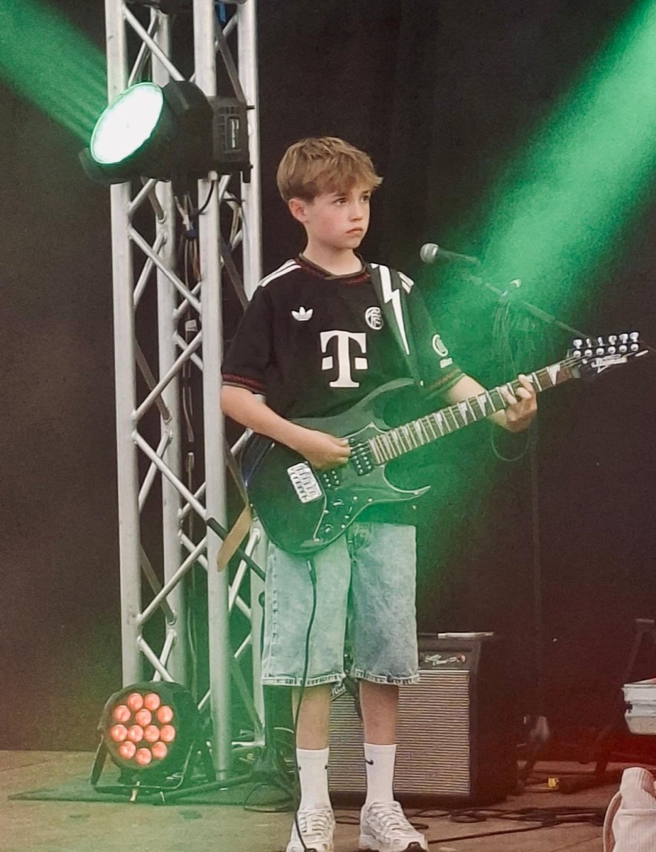 Junger Gitarrist im grünen Bühnenlicht auf der Kirmes Gehlert