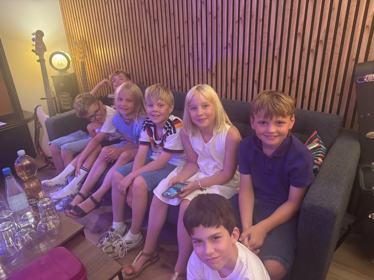 Bandkids auf dem Sofa im Tonstudio, Bässe und Gitarren an der Wand