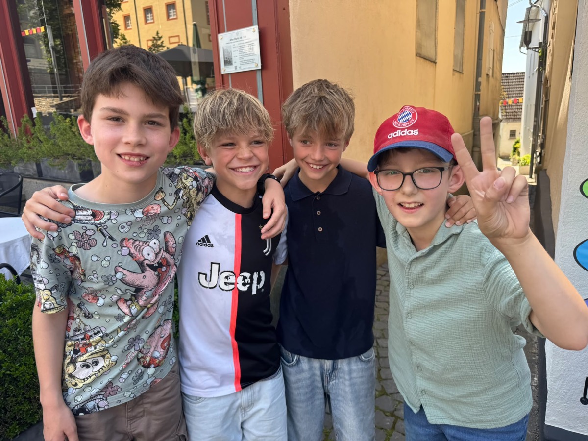 Vier Jungs Arm in Arm in der Altstadt