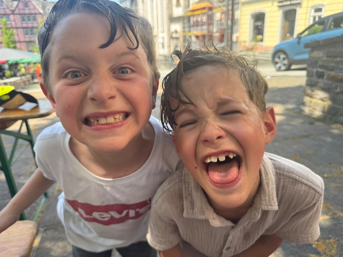 Zwei klatschnasse Jungs lachen in die Kamera